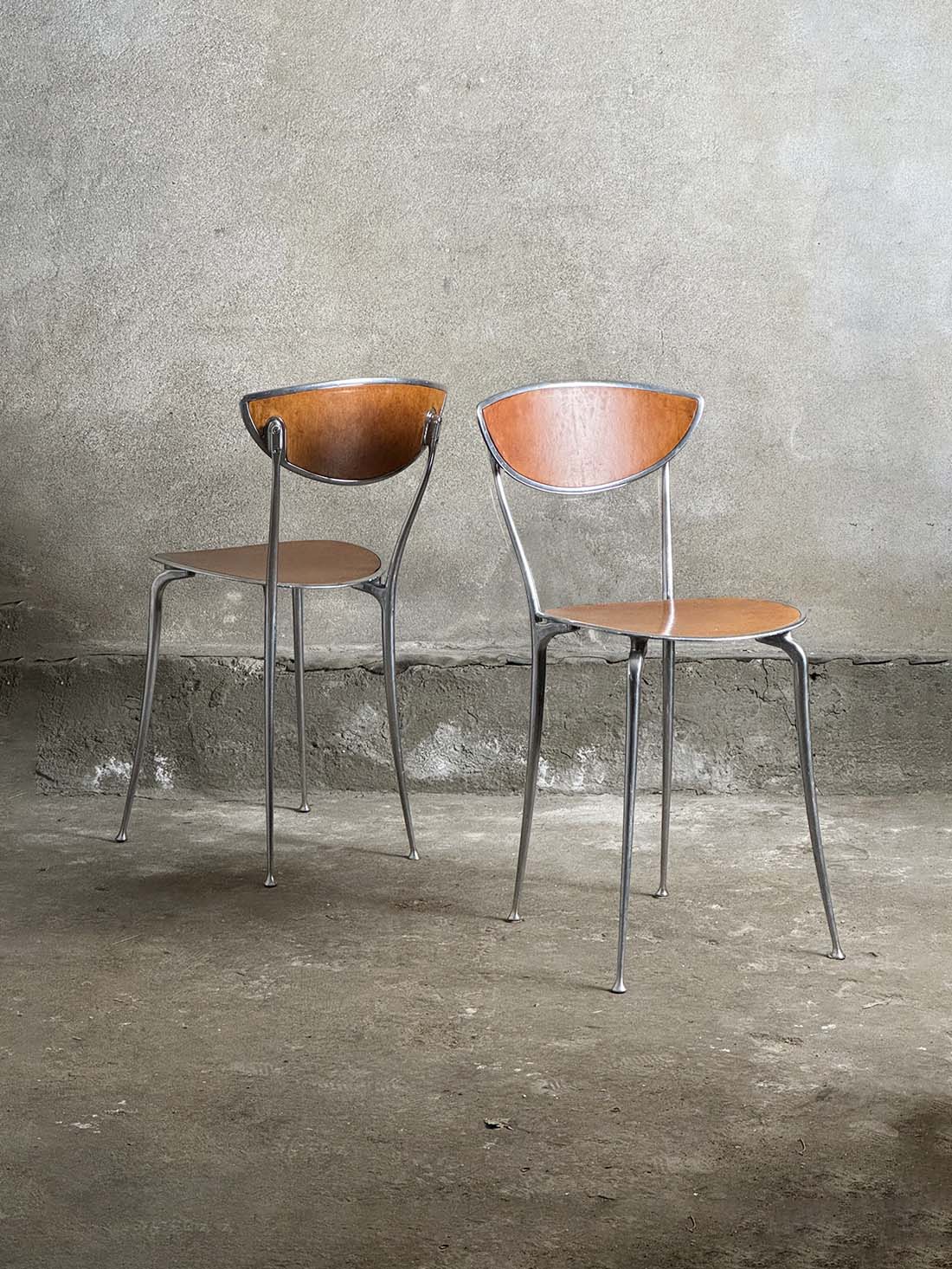 dwa aluminiowe krzesła Arper