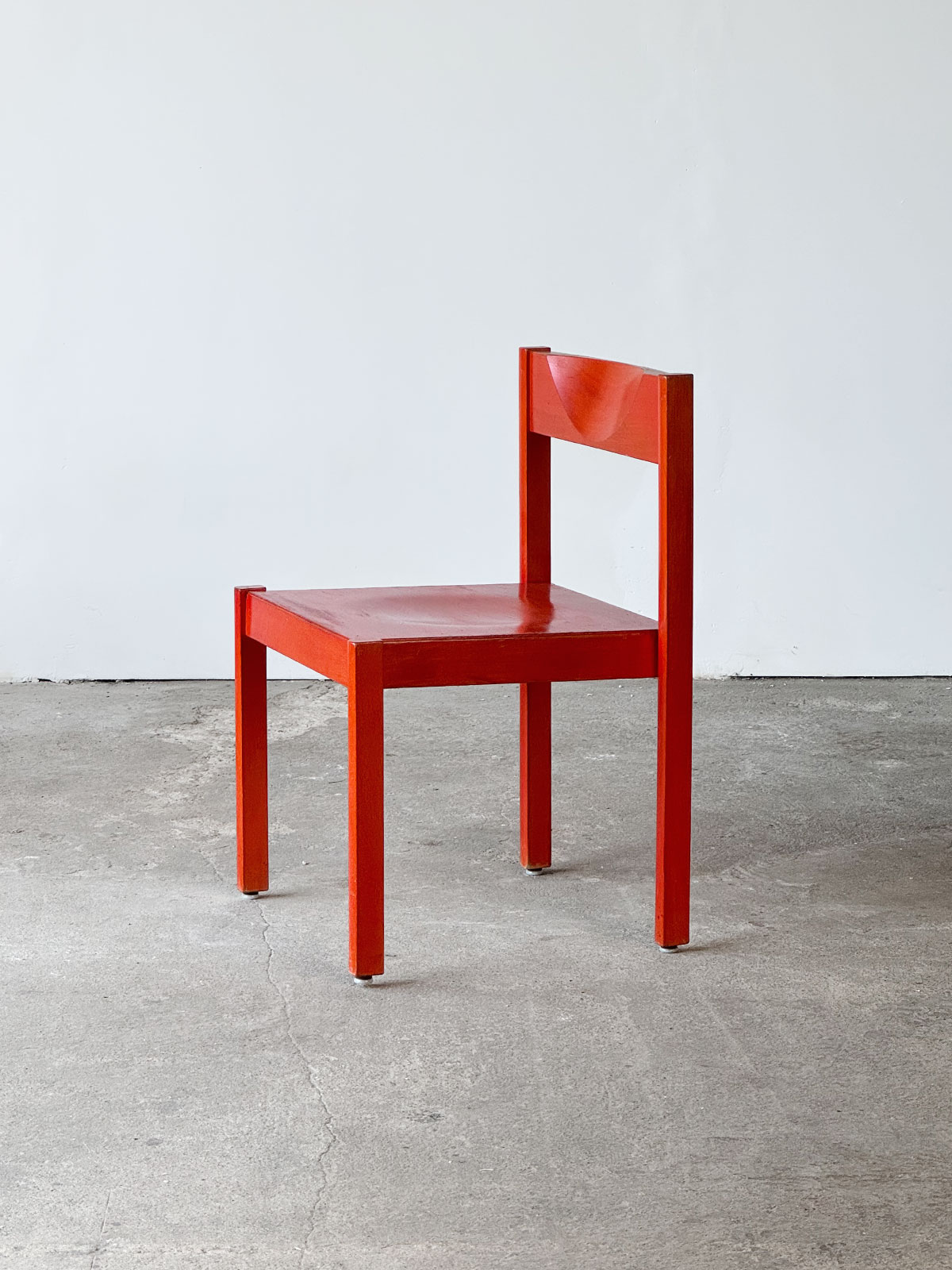 Krzesło Santo z drewna bukowego w intensywnym czerwonym kolorze, widok od przodu, z charakterystycznym wycięciem w oparciu.