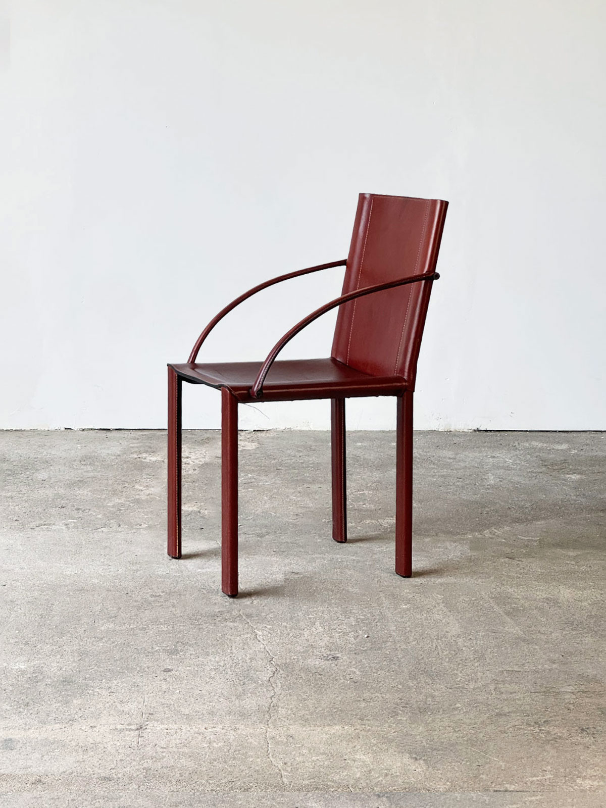 Krzesło CR1B z serii Carol, wykonane z bordowej skóry siodłowej, widok z boku, zaprojektowane przez Carlo Bartoliego.
