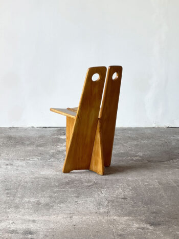 Drewniane krzesło Gilberta Marklunda widziane od tyłu, z widocznymi otworami w oparciu, w stylu brutalistycznym.