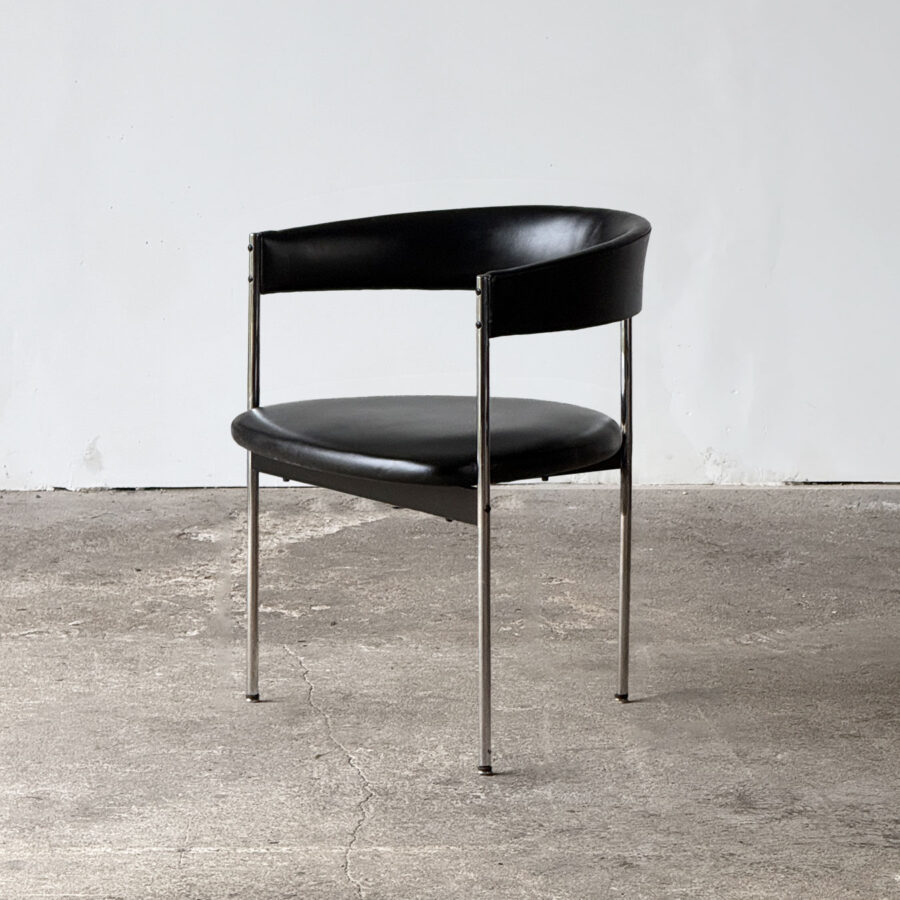 Widok boczny na krzesło trójnożne Dietera Wäckerlina, pokazujący chromowaną ramę i prosty profil siedziska.