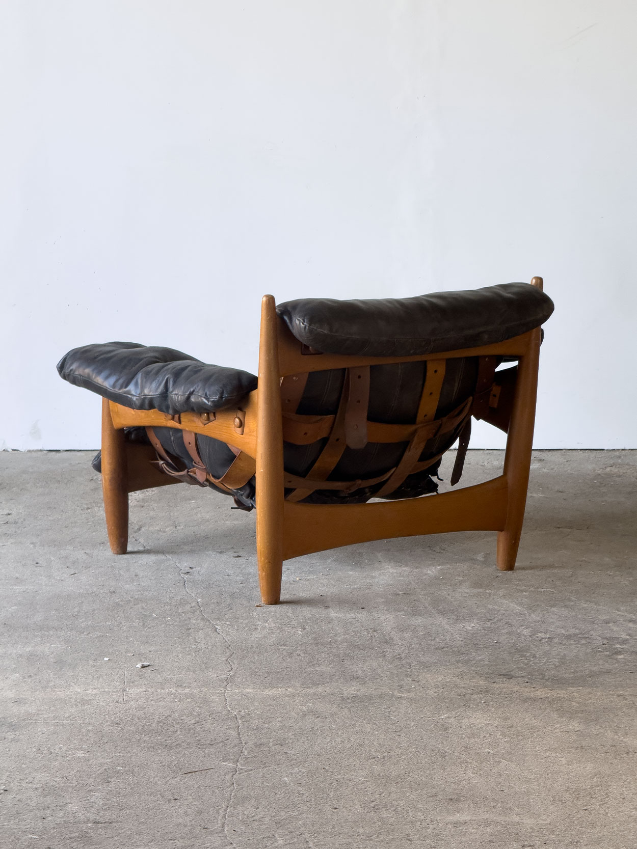 Tylny widok fotela „Sheriff” Sergio Rodrigues, drewno tekowe i skórzane pasy.