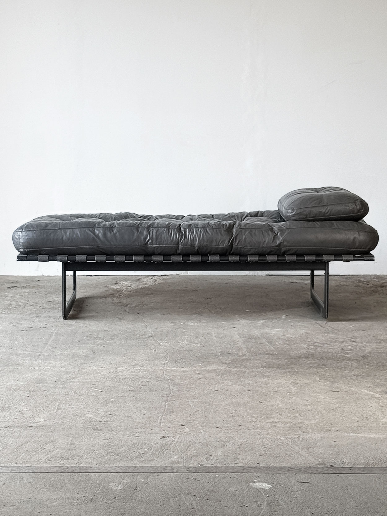 Leżanka „Grand Italia” Zanotta, widok z przodu, szara skóra i stalowa konstrukcja.
