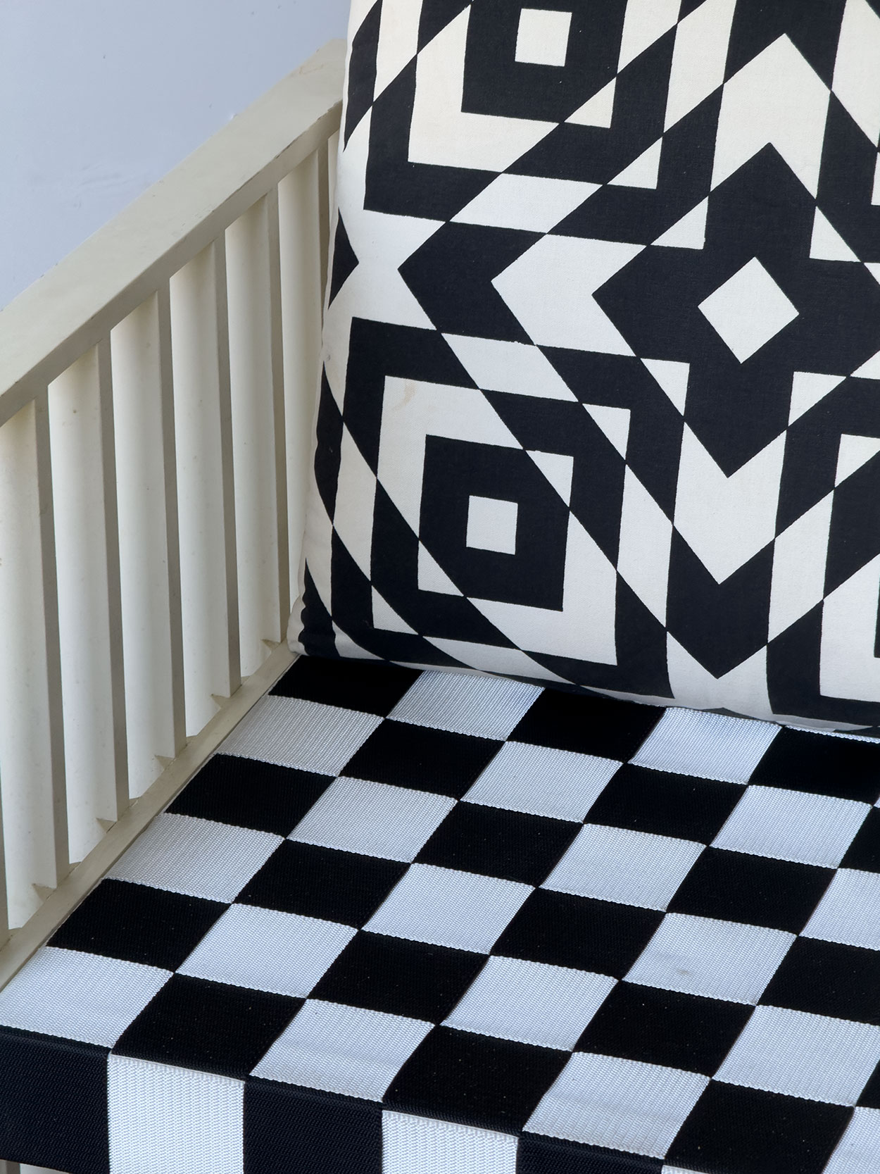 Zbliżenie na podłokietnik wykonany z lakierowanego drewna. Widoczne drobne odpryski i przetarcia charakterystyczne dla oryginalnego stanu zachowania.