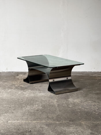 Stolik kawowy projektu Françoisa Monneta z giętą stalową podstawą i szklanym blatem