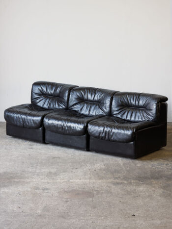 Modułowa kanapa De Sede DS-14 z lat 70. w czarnej skórze, ukazana w różnych konfiguracjach i zbliżeniach na detale.
