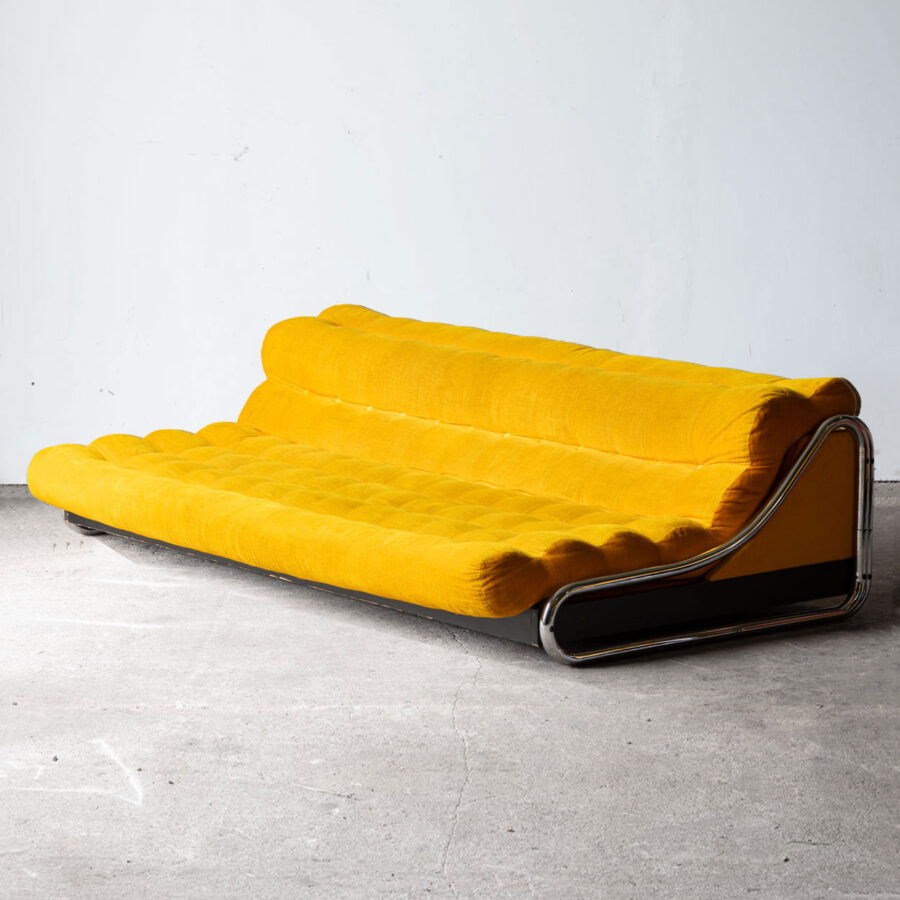 Sofa Impala Gillisa Lundgrena dla IKEA w żółtej tapicerce, rozłożona do funkcji spania.