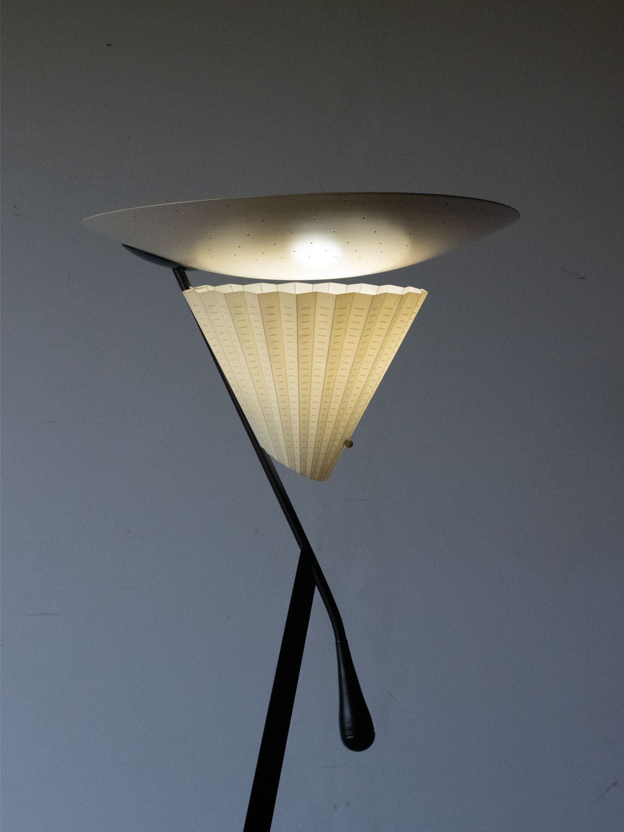 Lampa podłogowa Mantide 315 Mauro Canforiego dla Oluce z włączonym oświetleniem bezpośrednim i pośrednim.