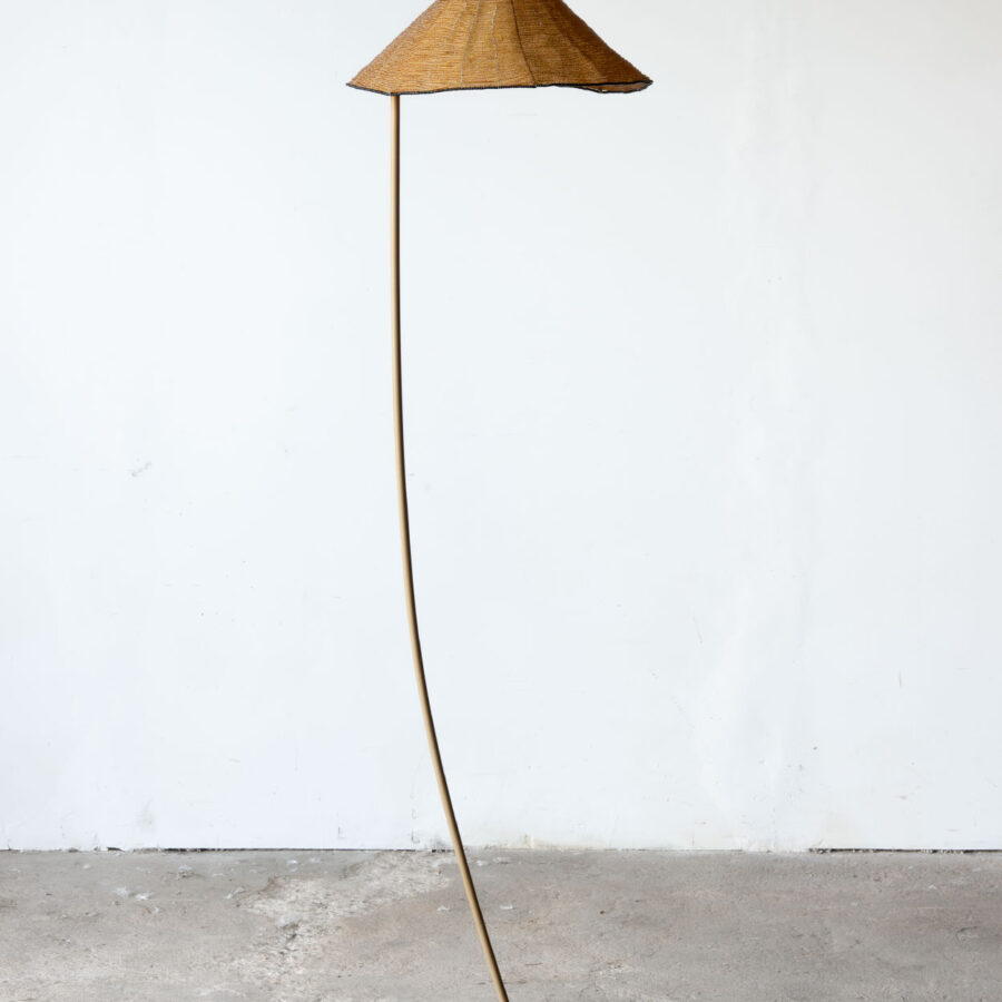 Lampa podłogowa Sarasar dla Leucos z brązowym szklanym kloszem i smukłym trzonem.